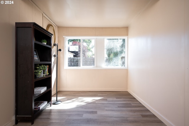 spare room featuring baseboards and wood finished floors