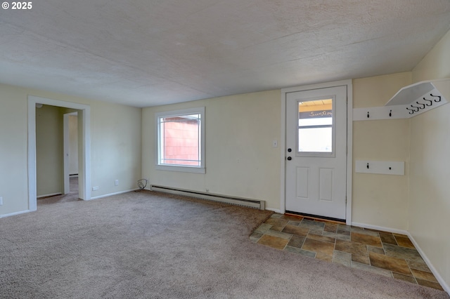 interior space featuring carpet floors, baseboards, a baseboard heating unit, and a textured ceiling