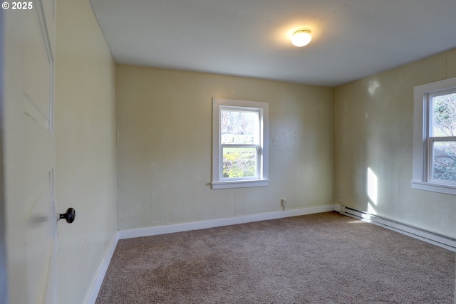 carpeted spare room with baseboard heating and baseboards