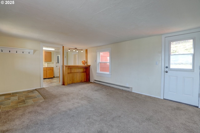 unfurnished living room featuring a baseboard radiator, baseboards, and light colored carpet