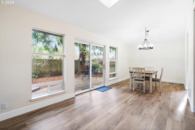 unfurnished dining area with light wood-type flooring and a chandelier