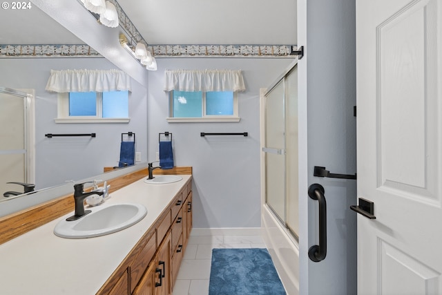 bathroom featuring tile patterned flooring, vanity, and shower / bath combination with glass door