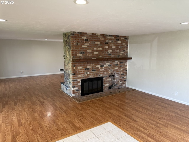 unfurnished living room featuring a fireplace and light hardwood / wood-style flooring