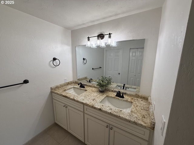 bathroom with tile patterned flooring, a textured ceiling, and vanity