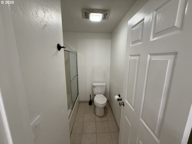 bathroom featuring tile patterned floors, toilet, and an enclosed shower