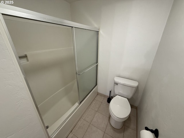 bathroom featuring tile patterned floors, toilet, and walk in shower