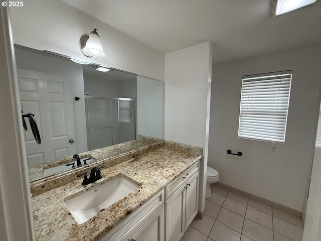 bathroom with tile patterned floors, a shower with door, vanity, and toilet