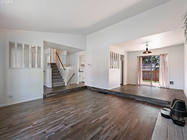 empty room with vaulted ceiling and dark hardwood / wood-style floors