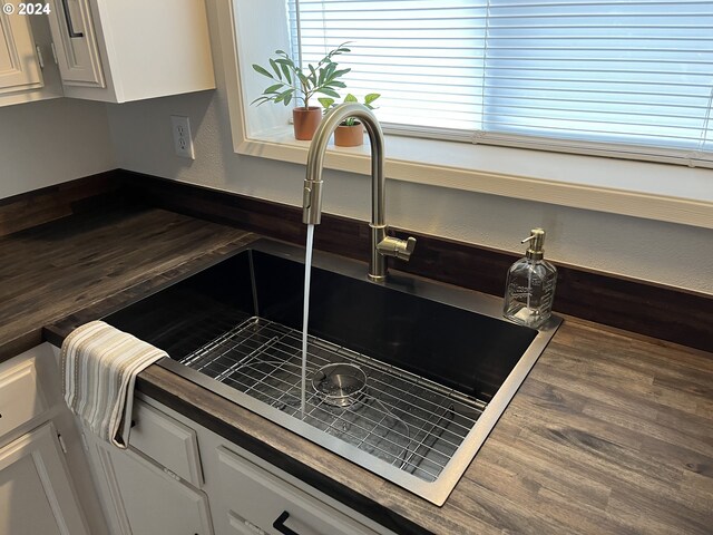 kitchen featuring dark hardwood / wood-style flooring, sink, white cabinets, and white appliances