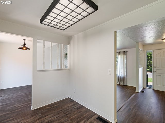 empty room featuring dark hardwood / wood-style floors and a textured ceiling