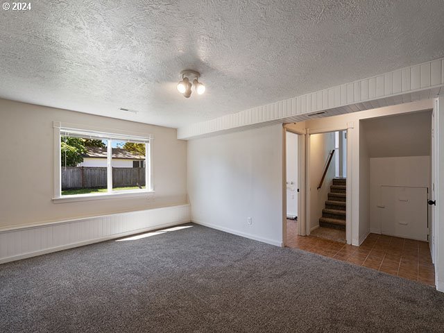 unfurnished dining area with a textured ceiling and dark hardwood / wood-style flooring