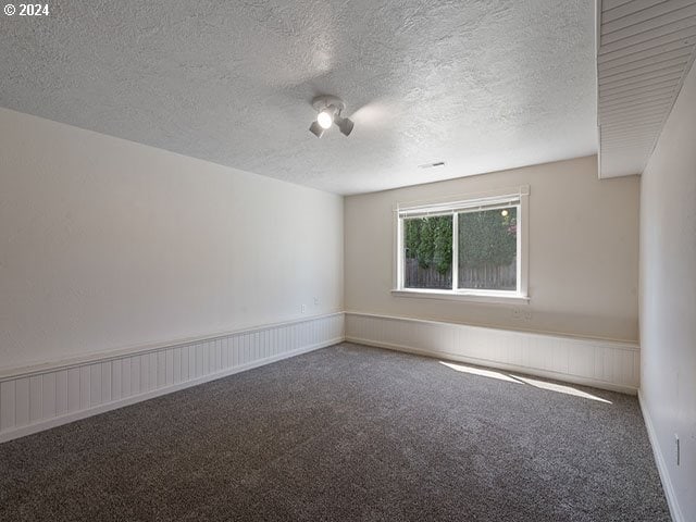 carpeted spare room featuring a textured ceiling