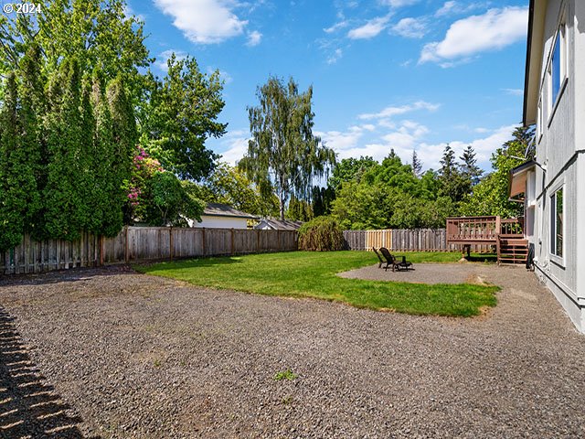 view of yard featuring a deck and an outdoor fire pit