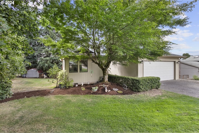 view of front facade featuring a garage, a shed, and a front lawn