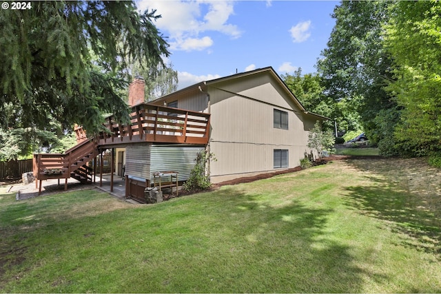 rear view of property with a deck and a lawn