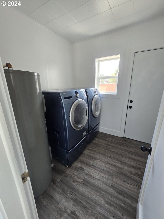 washroom featuring water heater, dark hardwood / wood-style floors, and washer and dryer