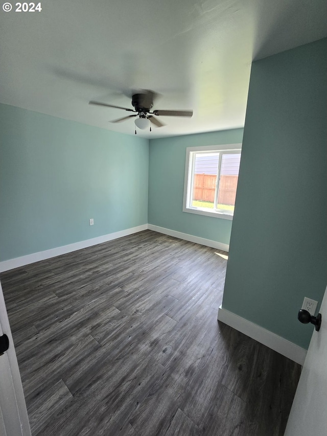 empty room with dark wood-type flooring and ceiling fan