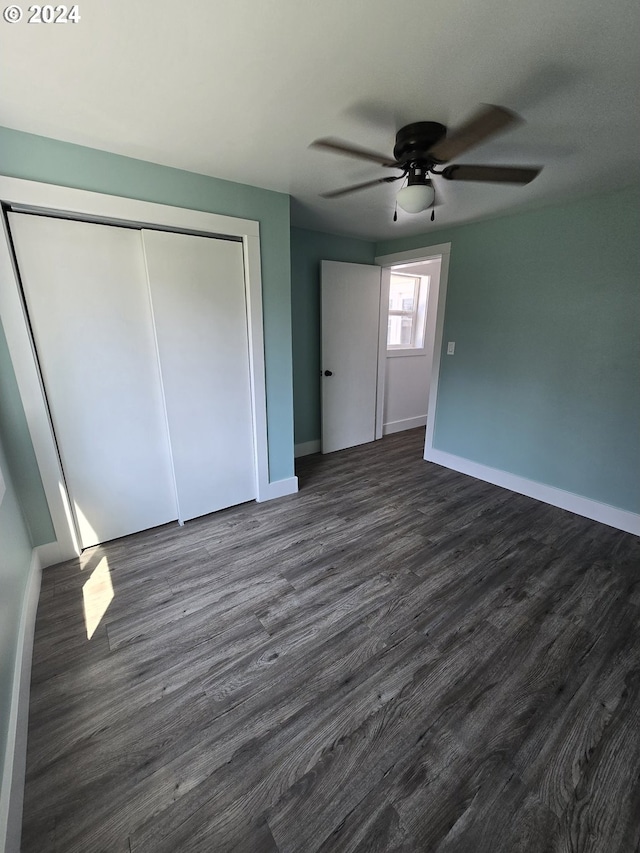 unfurnished bedroom featuring ceiling fan, dark hardwood / wood-style flooring, and a closet