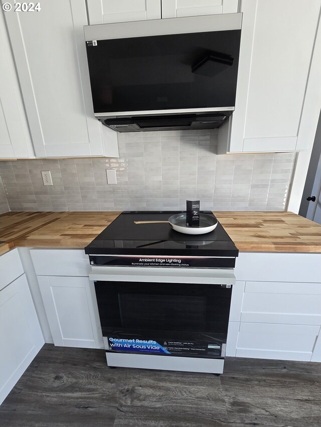 kitchen with white cabinets, electric range, and wood counters