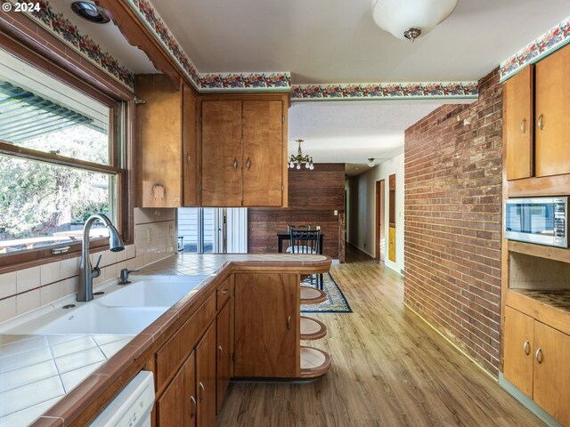 kitchen with white electric range, stainless steel microwave, backsplash, custom exhaust hood, and light hardwood / wood-style floors