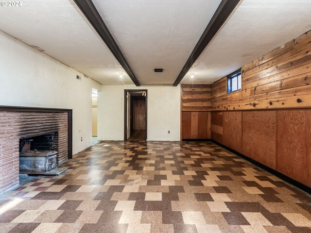 basement featuring a textured ceiling and wood walls