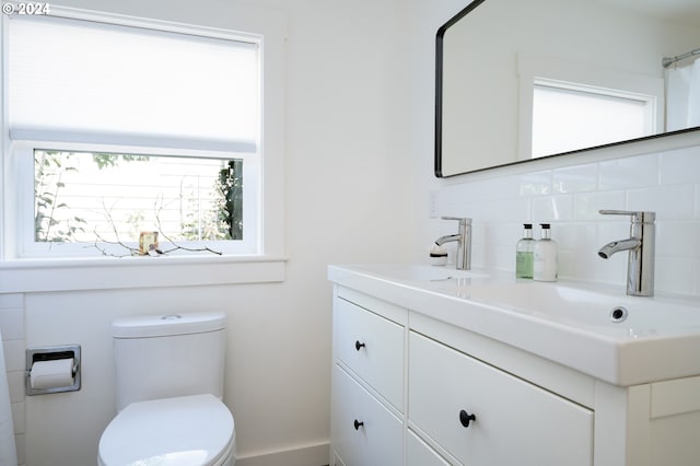 bathroom featuring vanity, plenty of natural light, toilet, and decorative backsplash