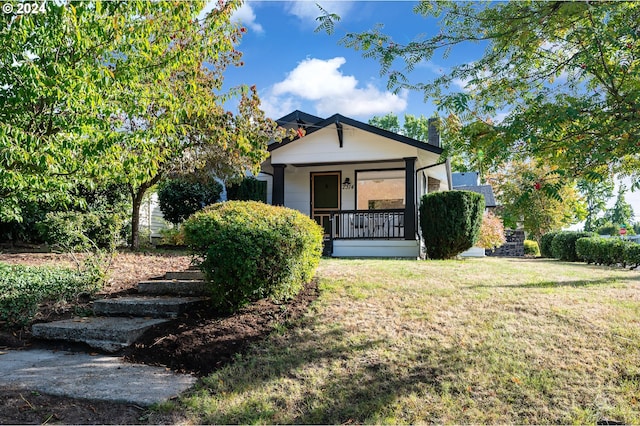 view of front of property with a porch and a front lawn