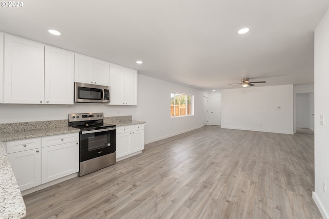 kitchen featuring white cabinets, light stone countertops, stainless steel appliances, and ceiling fan