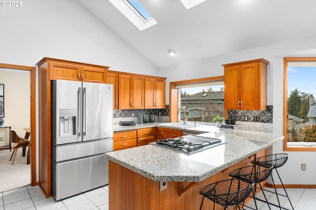 kitchen featuring sink, a wealth of natural light, a kitchen breakfast bar, and appliances with stainless steel finishes