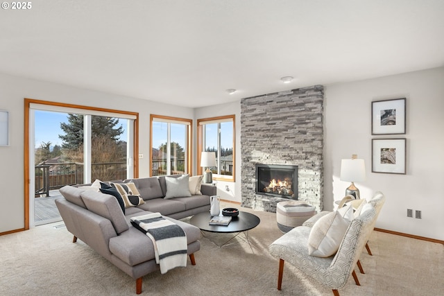 carpeted living room with a stone fireplace