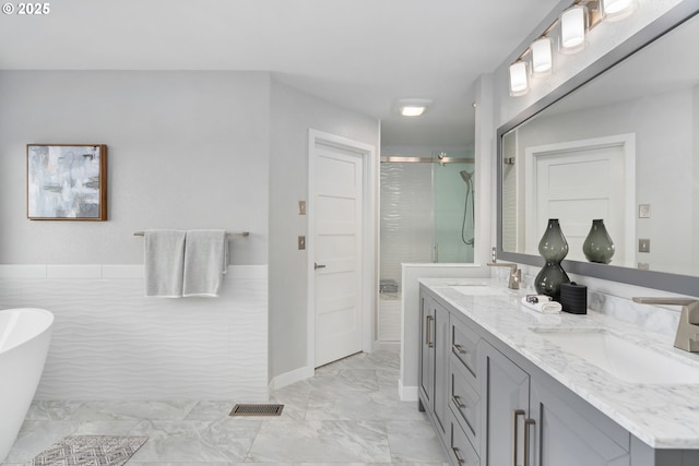 bathroom with vanity and shower with separate bathtub