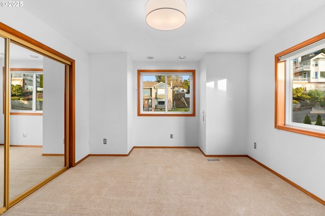 carpeted empty room featuring a wealth of natural light