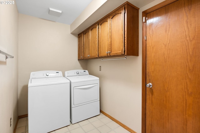 clothes washing area with cabinets and independent washer and dryer