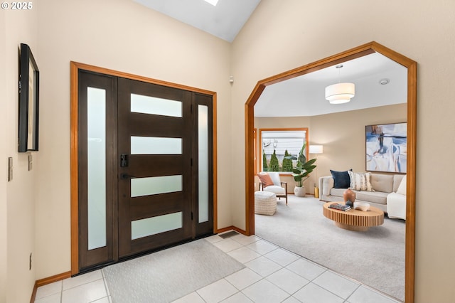 carpeted entryway with lofted ceiling