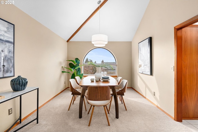 dining area featuring high vaulted ceiling and light carpet