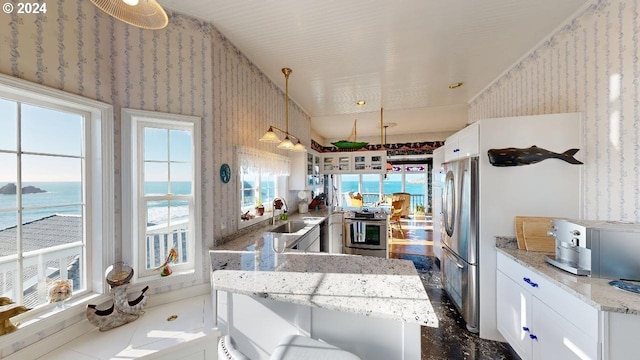 1545 Beach Ave, Brookings, OR 97415 - kitchen featuring appliances with stainless steel finishes, sink, light stone counters, a water view, and white cabinets