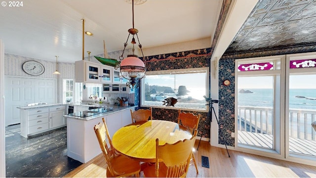 1545 Beach Ave, Brookings, OR 97415 - dining room featuring a water view, pendant lighting, sink, white cabinetry, and kitchen peninsula