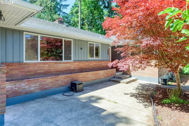 view of exterior entry with a patio area