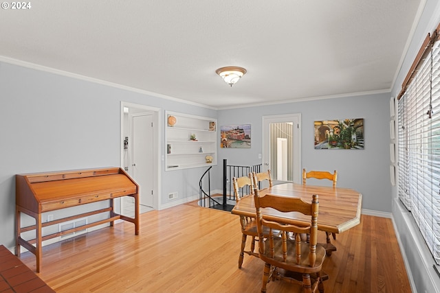 dining room with wood-type flooring and crown molding