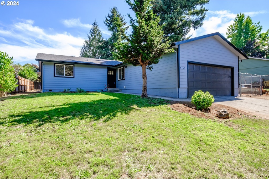 single story home with a garage, concrete driveway, a front lawn, and fence