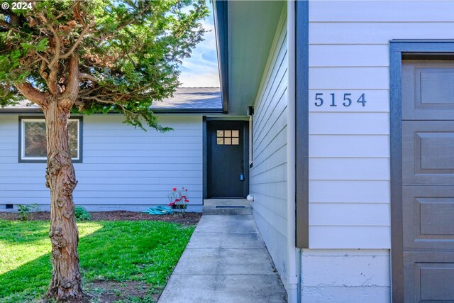 entrance to property with a lawn