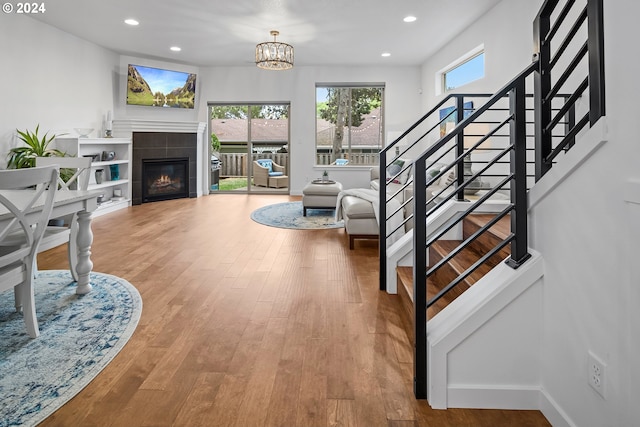 interior space featuring hardwood / wood-style floors, a tiled fireplace, a chandelier, and a wealth of natural light