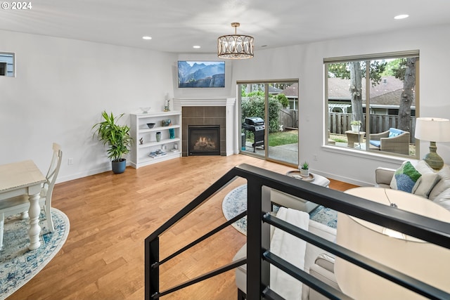 living room featuring hardwood / wood-style flooring, a chandelier, and a tile fireplace