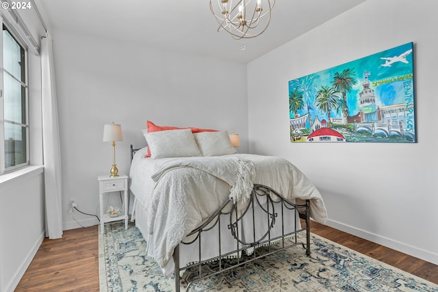 bedroom featuring an inviting chandelier and dark hardwood / wood-style flooring