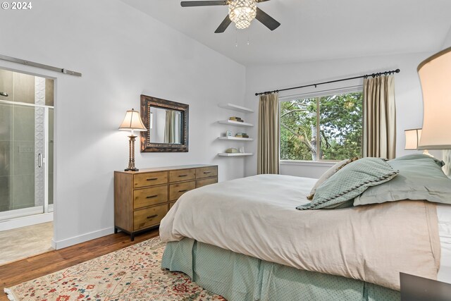 bedroom with lofted ceiling, ensuite bathroom, wood-type flooring, and ceiling fan