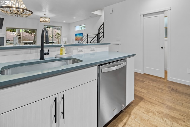 kitchen featuring stainless steel dishwasher, sink, white cabinets, and light hardwood / wood-style floors