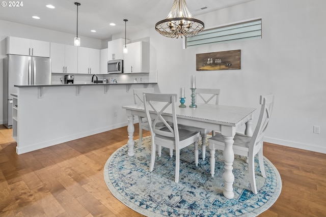 dining room featuring light hardwood / wood-style floors, a notable chandelier, and sink