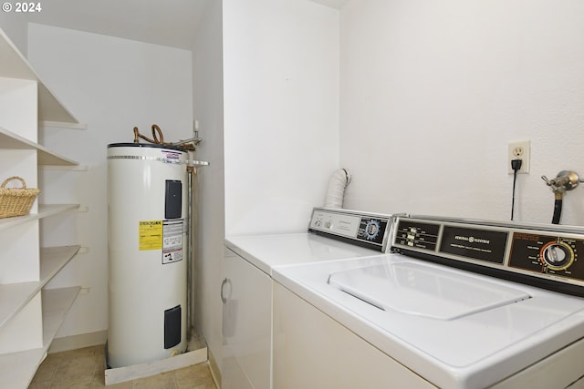 clothes washing area with water heater, washing machine and dryer, and light tile patterned floors