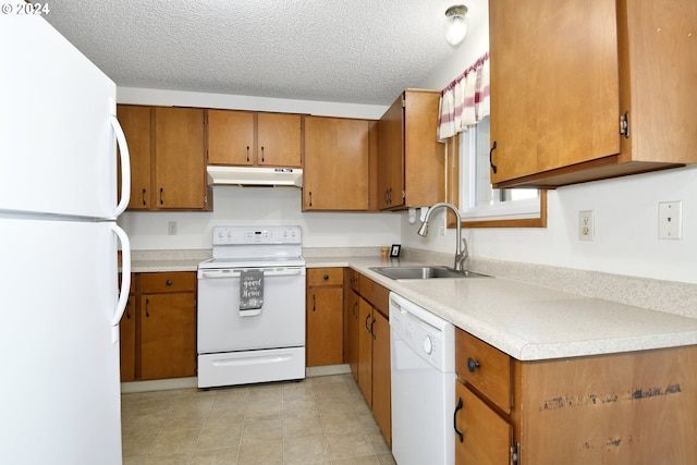 kitchen with a textured ceiling, sink, white appliances, and light tile patterned flooring