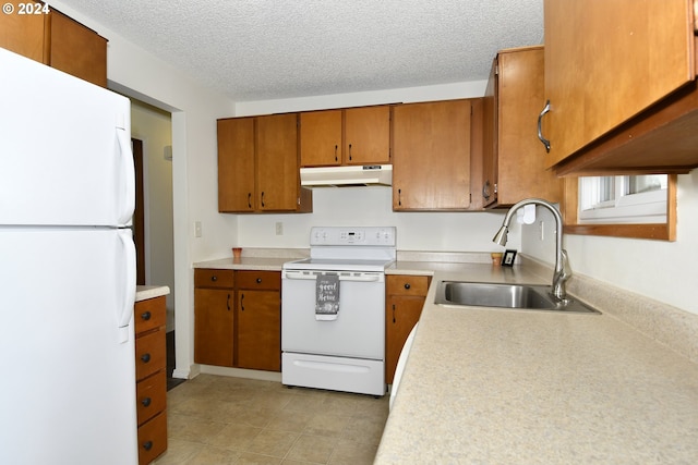 kitchen featuring a textured ceiling, sink, white appliances, and light tile patterned floors